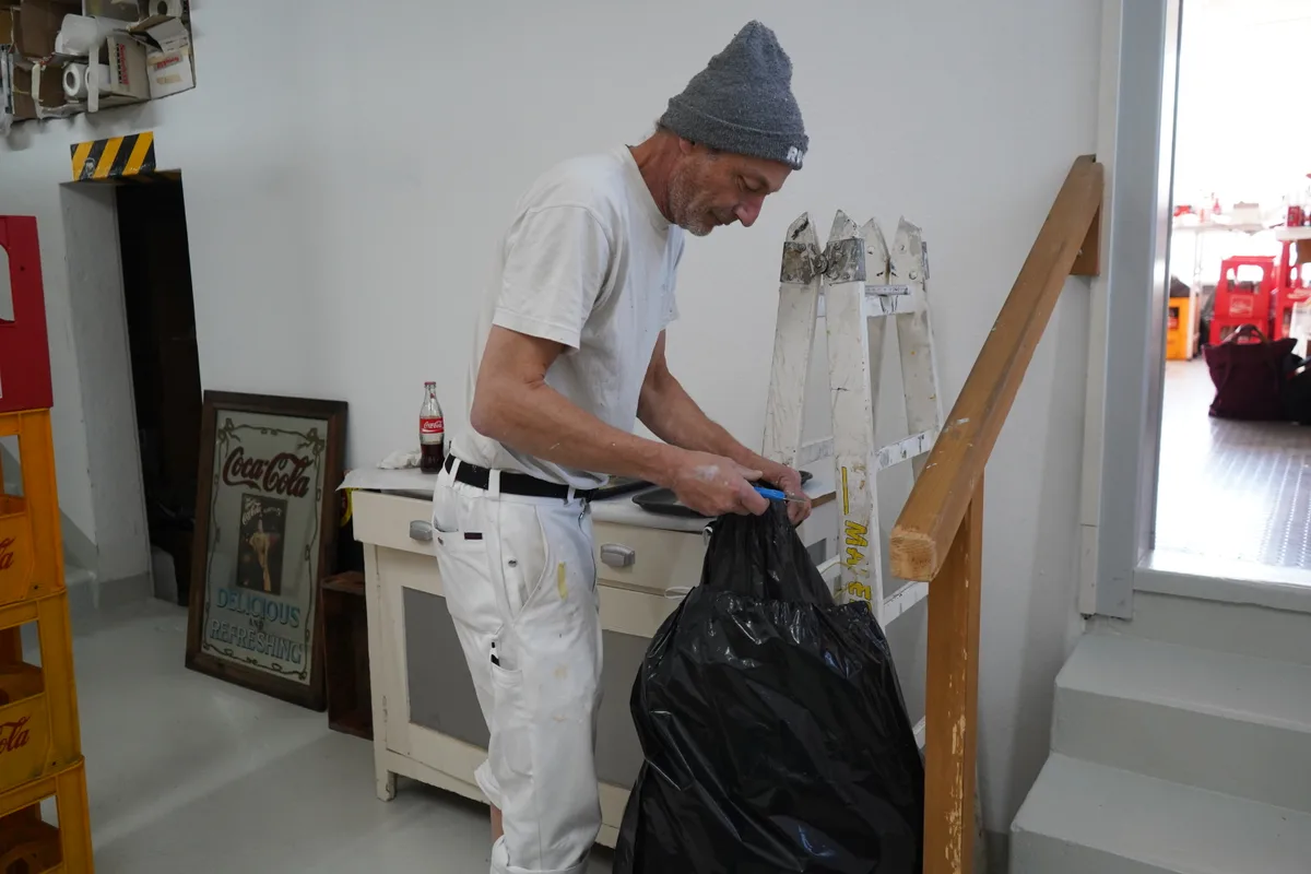 Man sieht Daniel Jaussi und seine Coca-Cola Sammlung.